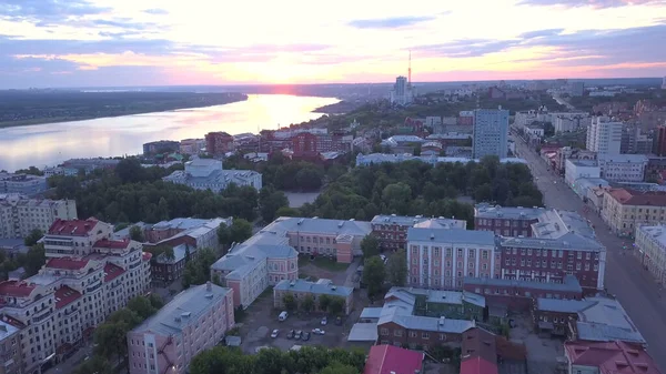 Schöne Aussicht auf die Stadt aus der Vogelperspektive. Clip. Ein eleganter, farbenfroher Sonnenuntergang mit Häusern und einem ruhigen Fluss. Urbane Ruhe . — Stockfoto