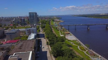 Gerçek bir manzara. Clip. Yazın şehir üzerinde uçuyorum. Dron 'dan bir video. Büyük binaların, köprünün ve nehrin olduğu güzel bir şehrin üzerinde uçuyor..