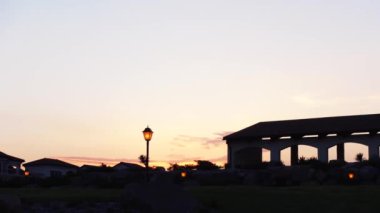 Kemerli bina ve fenerlerle gün batımı manzarası. Başla. Karanlık binaların siluetleri ve parlayan fenerlerle dolu güzel bir ufuk. Alacakaranlık arkaplanındaki kemerli bina manzarası