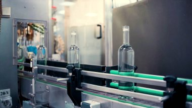 Cam şişe üretimi. Şarjör. Satışların artması için şişelerin kapaklarla kaplandığı üretim anı..