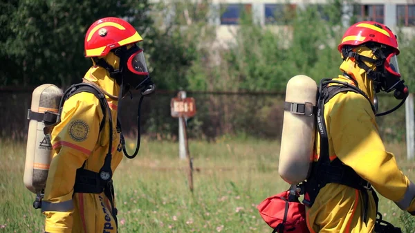Ověřovací práce v oblasti bezpečnosti životního prostředí. Klip. Muži v pracovním procesu hašení požáru s požárními hlásiči. — Stock fotografie