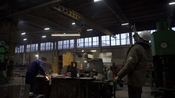 Trabajo en la fábrica. Clip. Los hombres trabajan en la producción pesada con hierro. — Foto de Stock