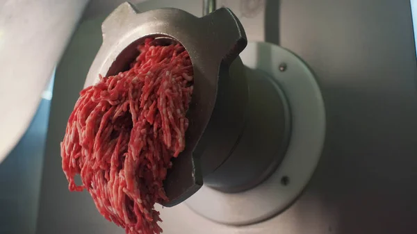 Conceito de cozinhar. Clipe. Um moedor de carne de metal finamente esfregando uma certa quantidade de carne em close-up. — Fotografia de Stock
