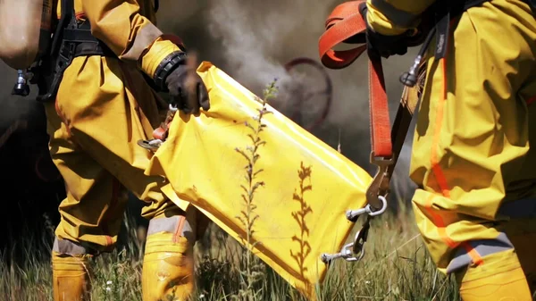 Feuerwehrleute setzen ihre Ausrüstung ein. Clip. Retter löschen mit Wasser oder überprüfen den Betrieb des Inventars . — Stockfoto