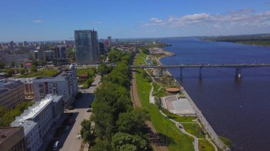 Gerçek bir manzara. Clip. Yazın şehir üzerinde uçuyorum. Dron 'dan bir video. Büyük binaların, köprünün ve nehrin olduğu güzel bir şehrin üzerinde uçuyor..