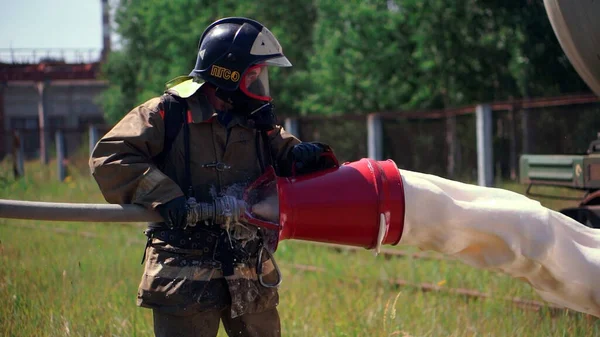 Arbeitsabläufe. Clip. Feuerwehrleute in Uniform kontrollieren die Ausrüstung und gießen Schaum und Wasser ab. — Stockfoto