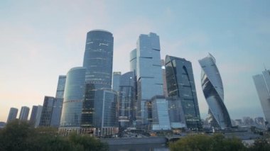 Presnenskaya Embankment.Action 'da, Moskova' da gelişmekte olan bir iş bölgesi. Çimlerin üzerinde kocaman şeffaf pencereleri olan büyük kuleler - ofis binaları