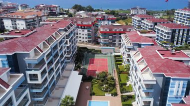 Bir İHA 'dan tatil köyünün görüntüsü. Şarjör. Arka planda geniş evleri ve dinlenme alanları olan berrak mavi deniz dağları görülebilir..