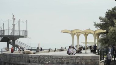 Rusya, Yalta - 16 Temmuz 2019: Yaz mevsiminde birçok turist deniz kenarında tatil yapıyor. Başla. Turistler için setin üzerinde güzel şemsiyeler. Turistik bölgede güneşli bir gün.