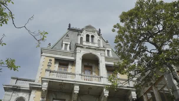 Beautiful Crimean castle. Action. Vorontsov Castle is located on the mountains next to beautiful green small bushes and trees on a clear blue sky background. — Stock Video