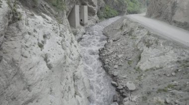Kayaların kenarları arasında güçlü bir su akıntısı sıkışır. Başla. Dağlar arasında bir vadide akan nehrin havadan görünüşü.