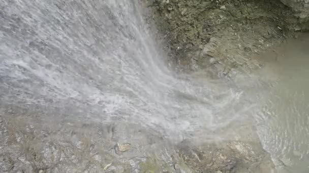 Cascade de montagne. L'action. Des ruisseaux minces avec des gouttes d'eau coulent sur les rochers de montagne et tombent. — Video