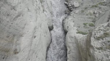 Kayaların kenarları arasında güçlü bir su akıntısı sıkışır. Başla. Dağlar arasında bir vadide akan nehrin havadan görünüşü.