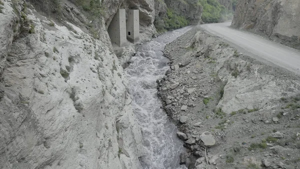 Ένα ισχυρό ρεύμα νερού συμπιέζεται μεταξύ των πλευρών των βράχων. Πάμε. Εναέρια άποψη του ποταμού που ρέει σε ένα φαράγγι ανάμεσα στα βουνά. — Φωτογραφία Αρχείου