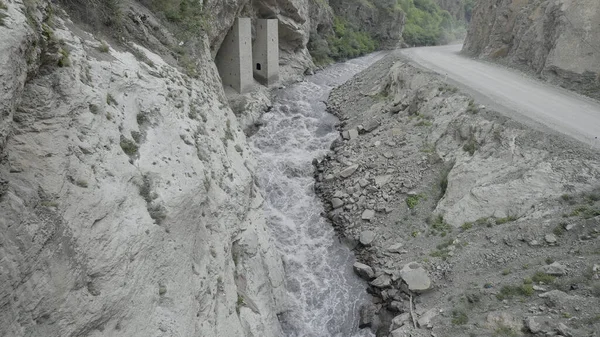 岩石两旁挤着一股强大的水流.行动。高山间峡谷中流淌的河流的空中景观. — 图库照片