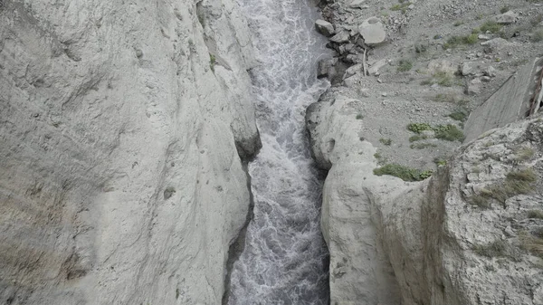 A sziklák oldalai között erős vízfolyás van. Felvétel. Légi kilátás a folyó folyik egy szurdokban hegyek között. — Stock Fotó
