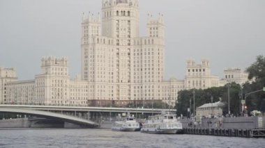 Seven Sisters 'dan biri, Stalinist tarzında güzel bir gökdelen, Moskova nehri ve turistik gemiler. Başla. Mimarlık kavramı, yürüyen insanlarla şehir seti..