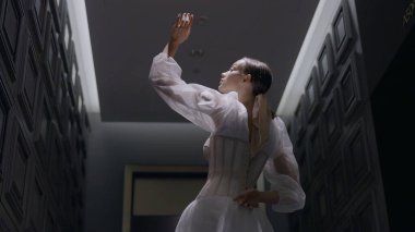 Kapalı alanda fotosansif durgunluk sırasında güzel, zarif bir gelin. Başla. Kameranın önünde korseli beyaz elbiseli bir kadın var..