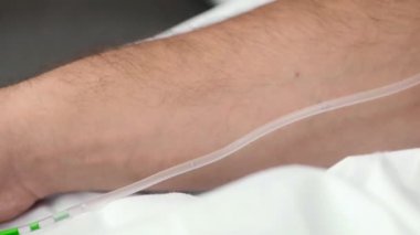 Sıvı tüpten damara geçer. Başla. Sıvı tüpten insan damarına gider. Damardan yeşil sıvı damlatılır