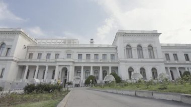 Beyaz yüzlü güzel, eski bir bina. Başla. Mavi gökyüzünün arka planında güzel beyaz bir malikane. Yazın şehrin dışındaki güzel beyaz bina