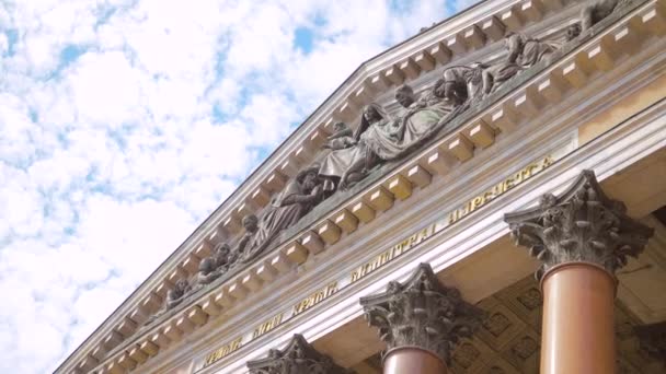상트페테르부르크에 있는 대성당의 아래쪽 사진. 행동. 아름다운 조각품들 이 오래 된 대성당의 일부와 기둥들에 걸려 있다. 하늘 배경에 기둥들이 있는 웅장 한 대 성당 — 비디오