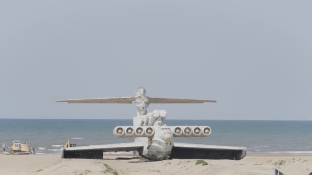 Plane landed on beach. Action. Aircraft is located on seashore. Plane is standing on beach on background of sea. Ekranoplan — Stock Video