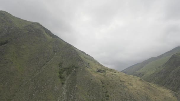 Τοπίο με άδεια βουνά. Πάμε. Βουνά από γκρίζα λουλούδια με έναν ομιχλώδη ουρανό πάνω από τον οποίο το drone πετάει και πυροβολεί. — Αρχείο Βίντεο