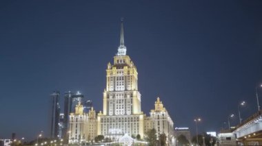 Moskova 'da Stalinist tarzında aydınlatılmış gökdelenli gece şehir manzarası. Başla. Koyu mavi gökyüzü arka planında güzel bir bina, mimari konsepti..