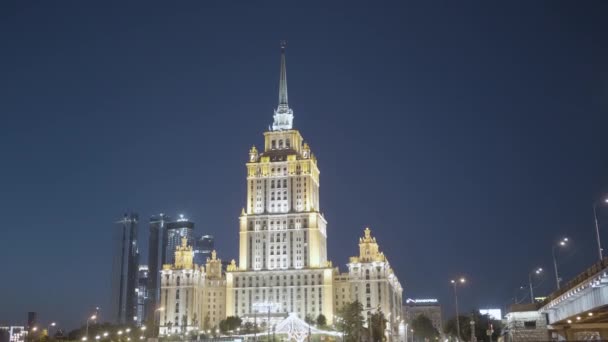 Późnonocny pejzaż miasta z oświetlonym drapaczem chmur w Moskwie zaprojektowany w stylu stalinowskim. Akcja. Piękny budynek na ciemnoniebieskim tle wieczornego nieba, koncepcja architektury. — Wideo stockowe