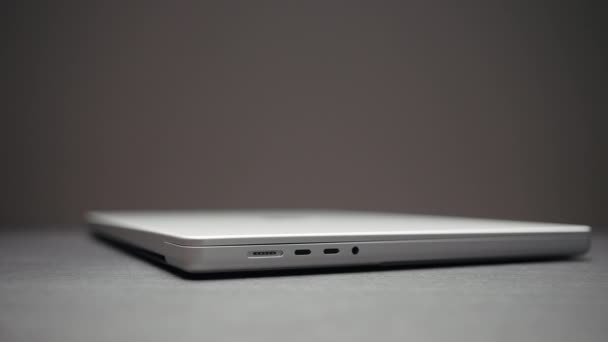 Side view of a new modern white laptop lying on a table surface against the wall. Action. Working from home, concept of freelance. — Stockvideo