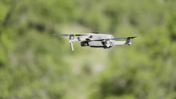 Un dron sobrevolando la naturaleza.Acción. Un pequeño dispositivo para tomar fotos desde una altura en la naturaleza que dispara videos y gira frente a hermosas montañas a la luz del día. — Vídeos de Stock