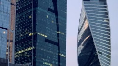 Güzel Moskova binaları. Başla. Arkalarında şık yüksek binalar ve evler ve turuncu bir akşam gökyüzünün göründüğü bir manzara..