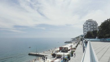 Güneşli bir günde tatil köyü manzarası. Başla. Güneşli günlerde yürümek için temiz bir set. Şehir setinde sakin deniz