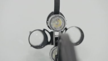 Ameliyat için yakınlaştırma gözlüğü. Başla. Beyaz arka planda el feneri olan profesyonel büyüteç. Cerrahi aletler ve aygıtlar