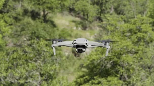 Havada İHA uçurmak. Başla. İnsansız hava aracı yeşil ağaçların üzerinden uçuyor. Hava aracının yeni modeli yazın yeşil ağaçlar vuruyor. — Stok video