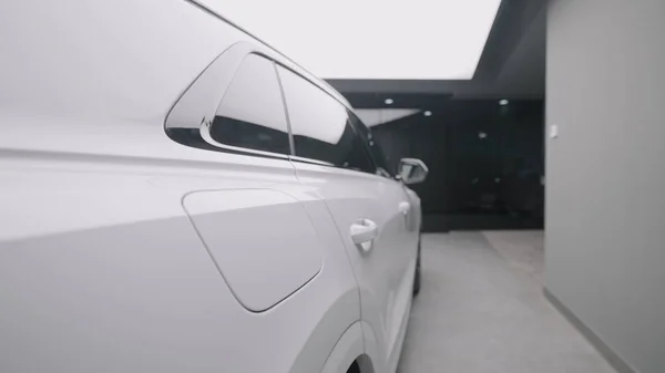 Vue latérale de la nouvelle voiture blanche en magasin. L'action. Belle apparence de nouvelle voiture blanche dans le salon de vente. Élégant Longue voiture à vendre — Photo