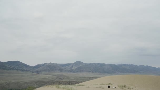 Hermosas montañas del desierto. Acción. El desierto contra el cielo blanco detrás de las grandes montañas ligeramente verdes y todo en la arena. — Vídeos de Stock