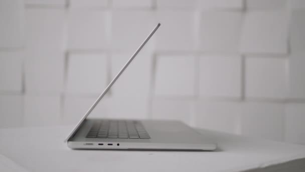 Munkahelyi. Felvétel. Egy fényes fehér futage fehér falak és egy fehér asztal, amelyen van egy szürke laptop síkképernyős . — Stock videók