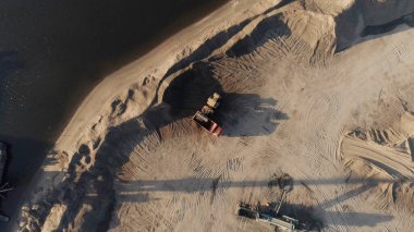 Sahilde inşaat var. Başla. Büyük ekipmanlar ormanın ve şehrin yanına büyük bir kamyon ve denizin yanında bir gemi inşa eder..