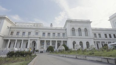 Beyaz yüzlü güzel, eski bir bina. Başla. Mavi gökyüzünün arka planında güzel beyaz bir malikane. Yazın şehrin dışındaki güzel beyaz bina