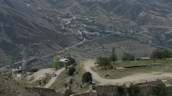 Vista aérea de um helicóptero sobrevoando a pequena aldeia localizada nas montanhas. Acção. Região montanhosa com o assentamento residencial. — Fotografia de Stock