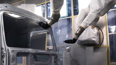 Robot teknolojisi arabanın gövdesini boyar. Sahne. Robot eller araba gövdesini boyar. Üretimde robotik makine kullanarak araba boyamak