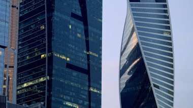 Güzel Moskova binaları. Başla. Arkalarında şık yüksek binalar ve evler ve turuncu bir akşam gökyüzünün göründüğü bir manzara..