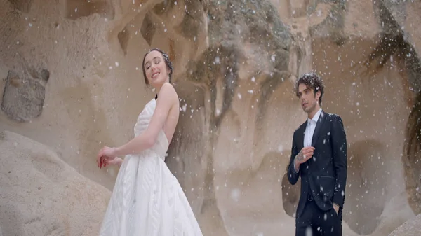 Φωτογράφηση των νεόνυμφων στη φύση. Πάμε. Ένα χαριτωμένο ζευγάρι με κοστούμια γάμου στα βουνά ποζάροντας για μια φωτογράφηση και το χιόνι του. — Φωτογραφία Αρχείου