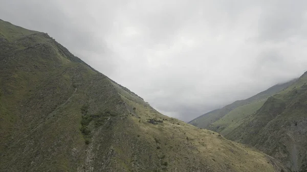 Paesaggio di montagne vuote. Azione. Montagne di fiori grigi con un cielo nebbioso su cui vola il drone e spara. — Foto Stock
