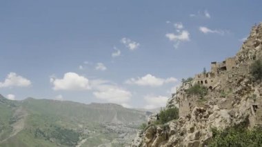 Yazın dağlarda antik taş şehir. Başla. Mavi gökyüzünün arka planında terk edilmiş bir rock şehrinin güzel manzarası. Yaz dağlarında antik taş şehir