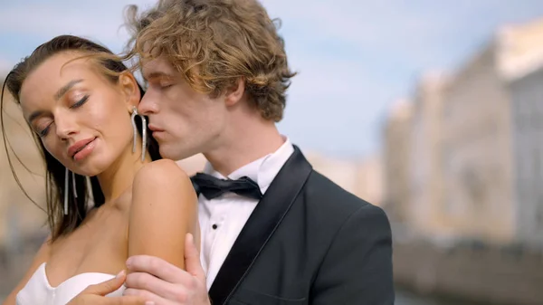 Wedding photo shoot. Action. A couple poses next to St. Isaac s Cathedral , a young man with long curly hair and his bride with bare shoulders and long earrings — Stockfoto