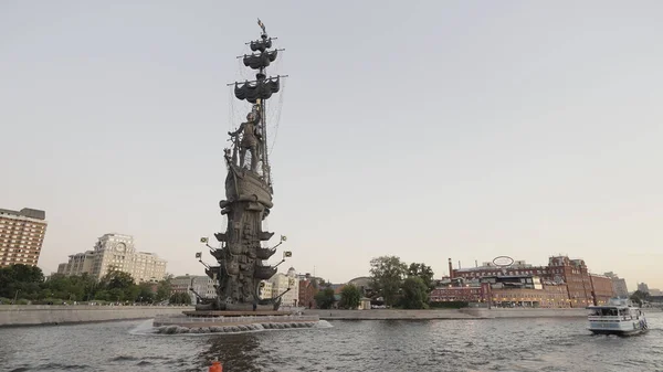 Escultura de bronze em um pedestal de granito, localizado na Praça Petrovsky de Voronezh.Ação. Um tiro paisagem enquanto navega no rio ao lado de um pequeno navio na parte de trás da casa e bonito nevoeiro — Fotografia de Stock