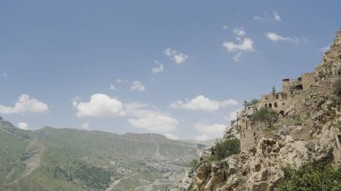 Yazın dağlarda antik taş şehir. Başla. Mavi gökyüzünün arka planında terk edilmiş bir rock şehrinin güzel manzarası. Yaz dağlarında antik taş şehir