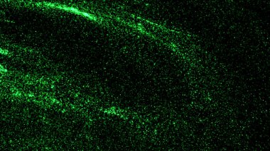 Yeşil parıltılı siyah bir arkaplan. Hareket. Parlak yeşil parçacıkların soyutlamada hareket ettiği arkaplan.